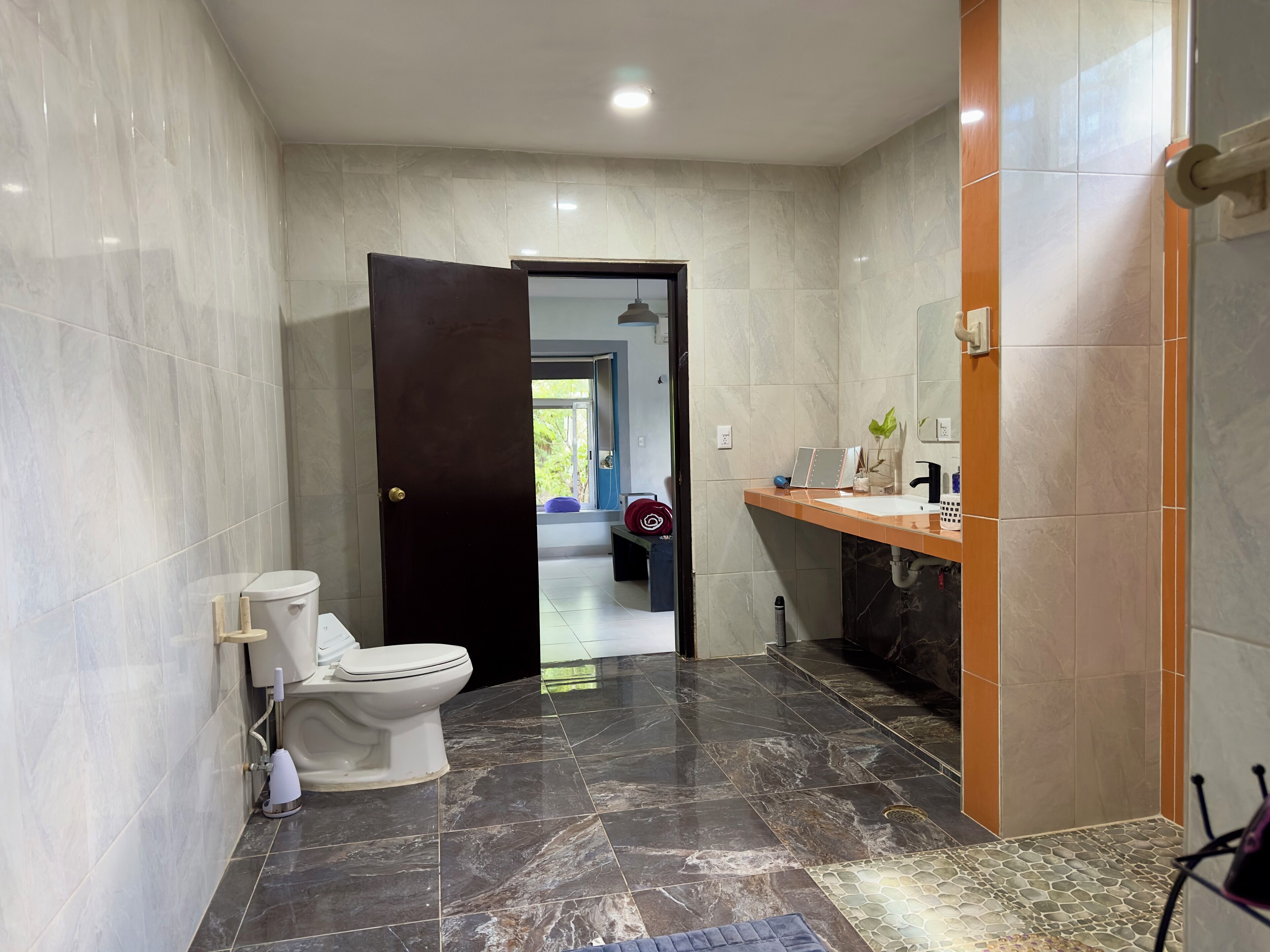 A modern bathroom with a toilet, sink, and shower area.