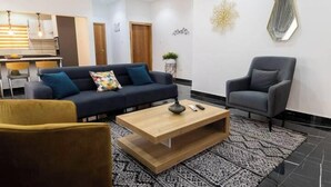 A modern living room with a sofa, armchair, and coffee table. - Peaceful Escape in Tema Community 25 (Dawhenya)