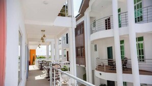 A multi-level building with balconies, railings, and outdoor seating areas. - Peaceful Escape in Tema Community 25 (Dawhenya)