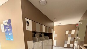 A hotel room with a tiled floor, a minibar, a sink, and a mirror. - Moderno y equipado estudio en Los Dominicos (Santiago)