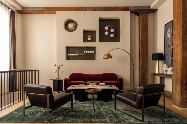 A modern living room with a red sofa, two armchairs, a coffee table, and decorative wall art. - The Artisan's Duplex - 8Bd/5.5Bth w/2 Car Parking! (Philadelphia)