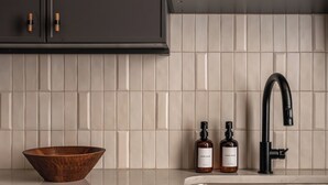 A kitchen with dark cabinets, a white tiled backsplash, a stainless steel sink, and a wooden bowl. - The Artisan's Duplex - 8Bd/5.5Bth w/2 Car Parking! (Philadelphia)