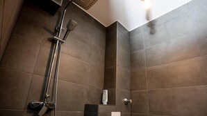 Een douche met een handdouche en een wandmengkraan.