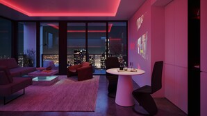 A modern living room with a city view, a round table, and red ambient lighting. - Modern 3BR - 3BA Apartment with Breathtaking Views (Miami)