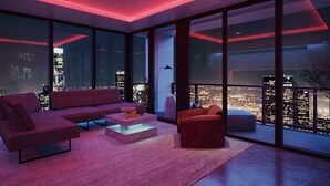 A modern living room with a city view, featuring a sectional sofa, a coffee table, and a red accent chair. - Modern 3BR - 3BA Apartment with Breathtaking Views (Miami)