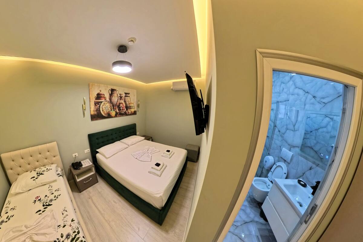 Un dormitorio con cama, mesita de noche y un cuadro en la pared.