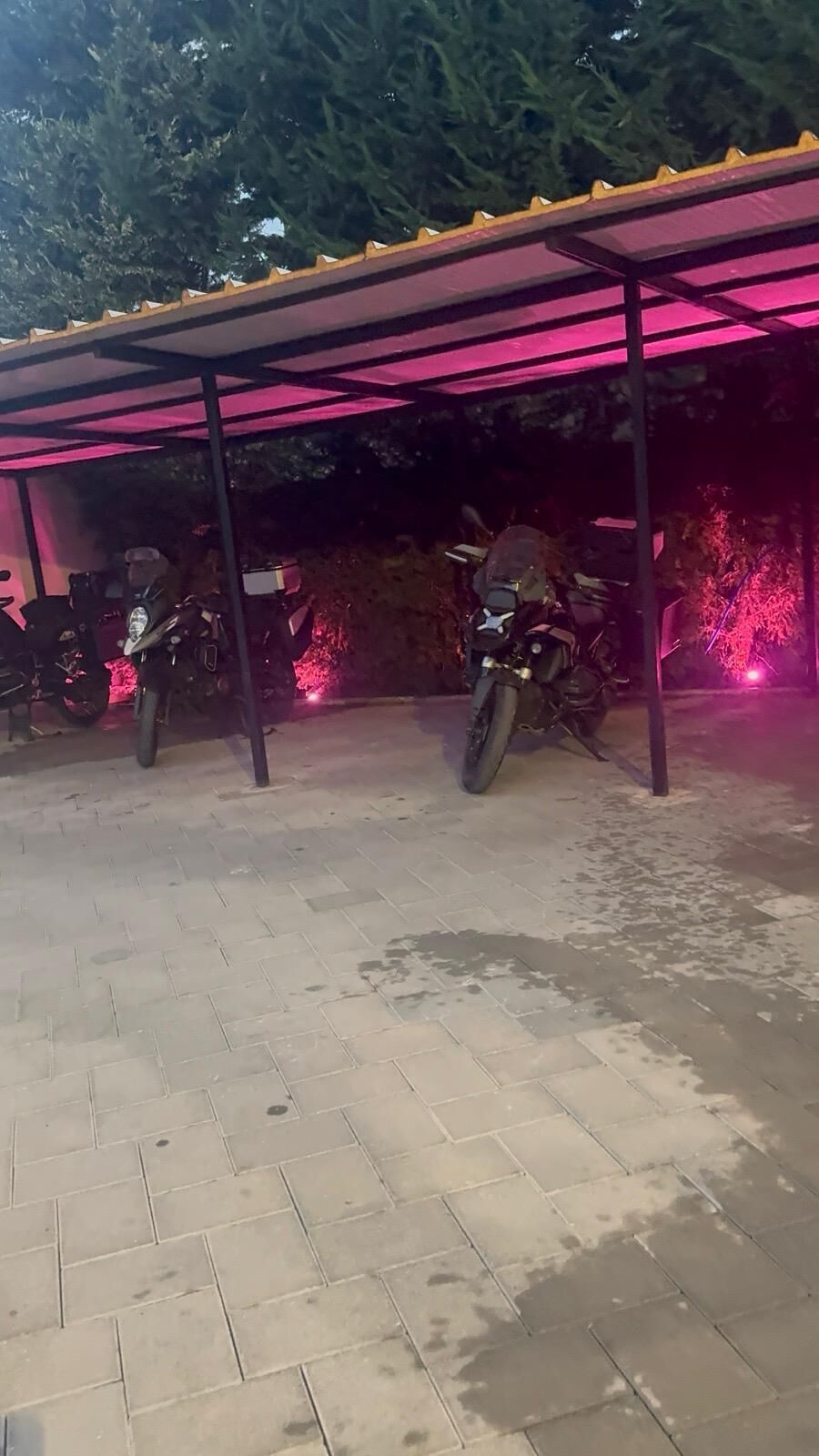 Ein überdachter Parkbereich mit zwei unter einem Schutzdach abgestellten Motorrädern.