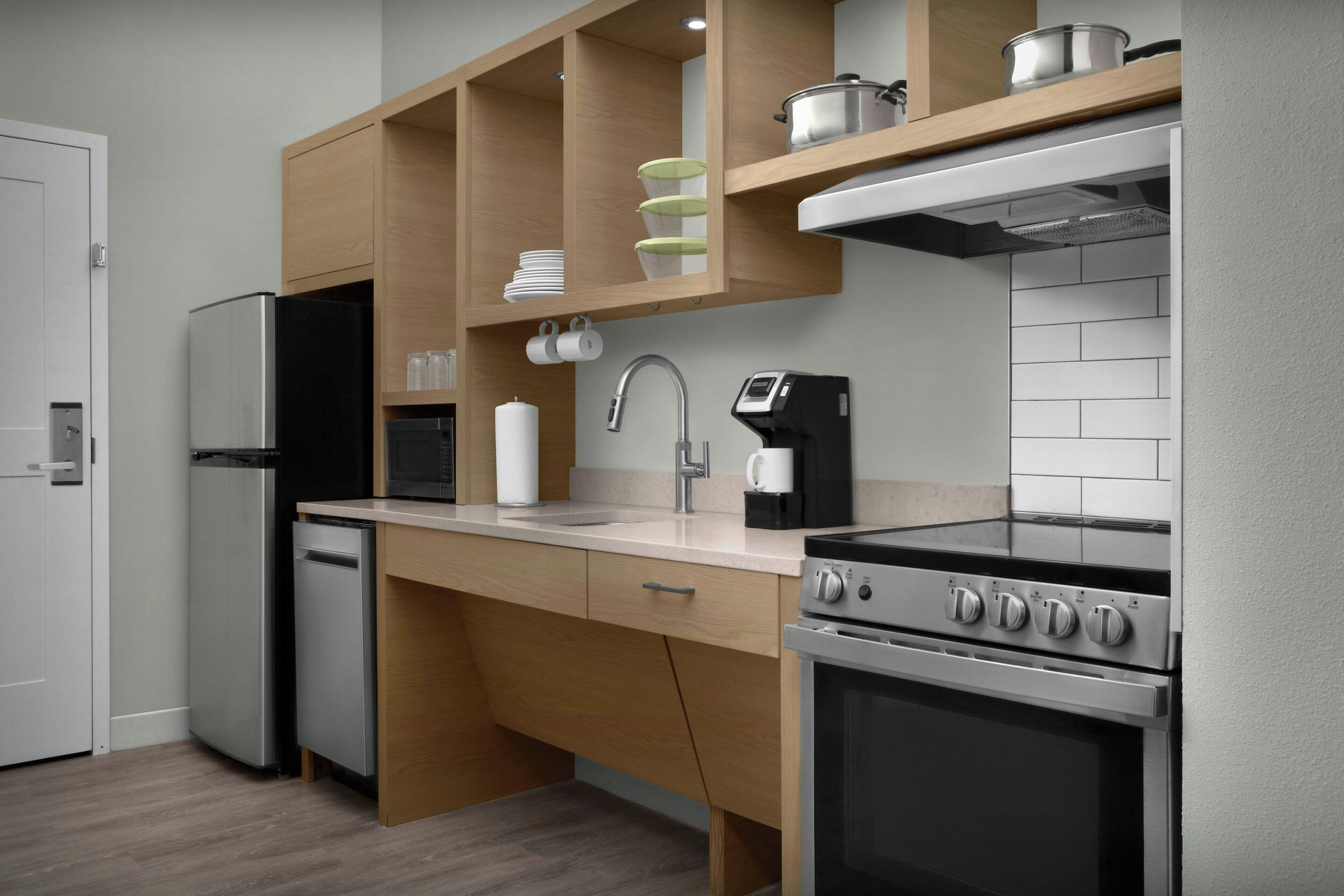 A modern kitchen with a built-in oven, a coffee maker, and wooden cabinets.