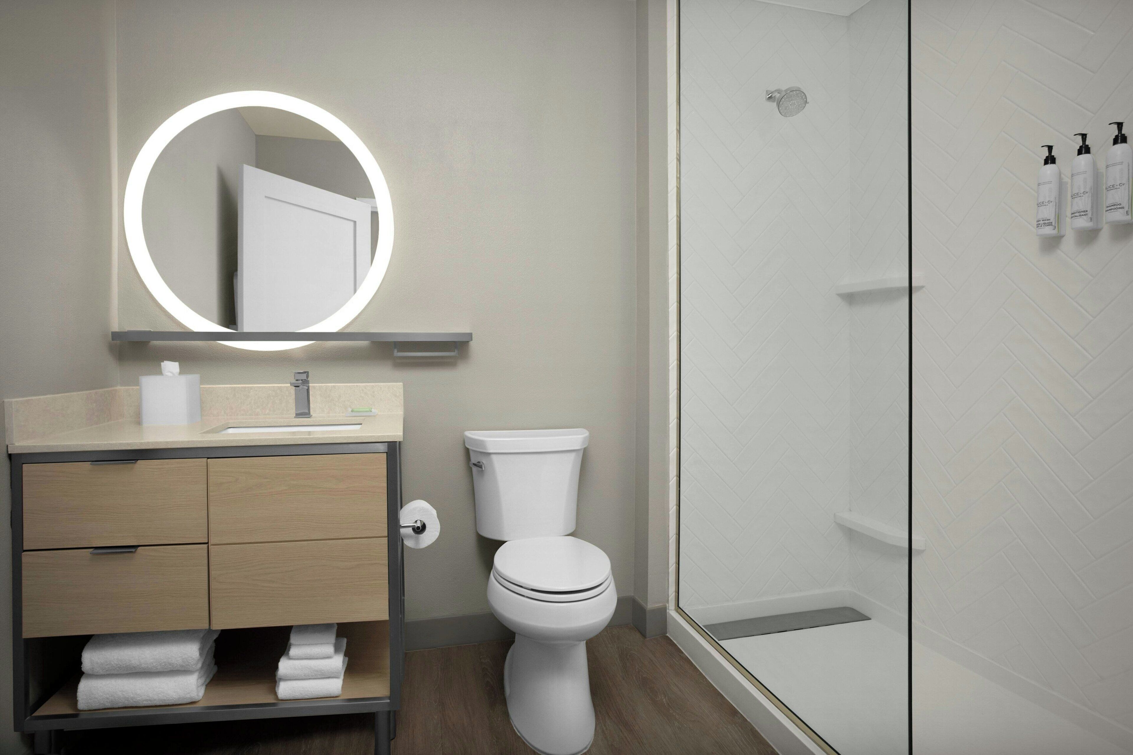 Un baño moderno con inodoro, lavabo y ducha.