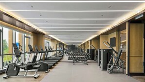 Ein modernes Fitnessstudio mit Laufbändern, Kurzhanteln und Kraftgeräten.