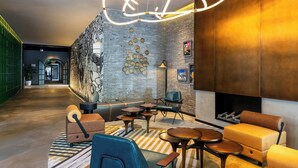 Un espace de détente moderne avec des canapés en cuir, des tables rondes et un luminaire original.