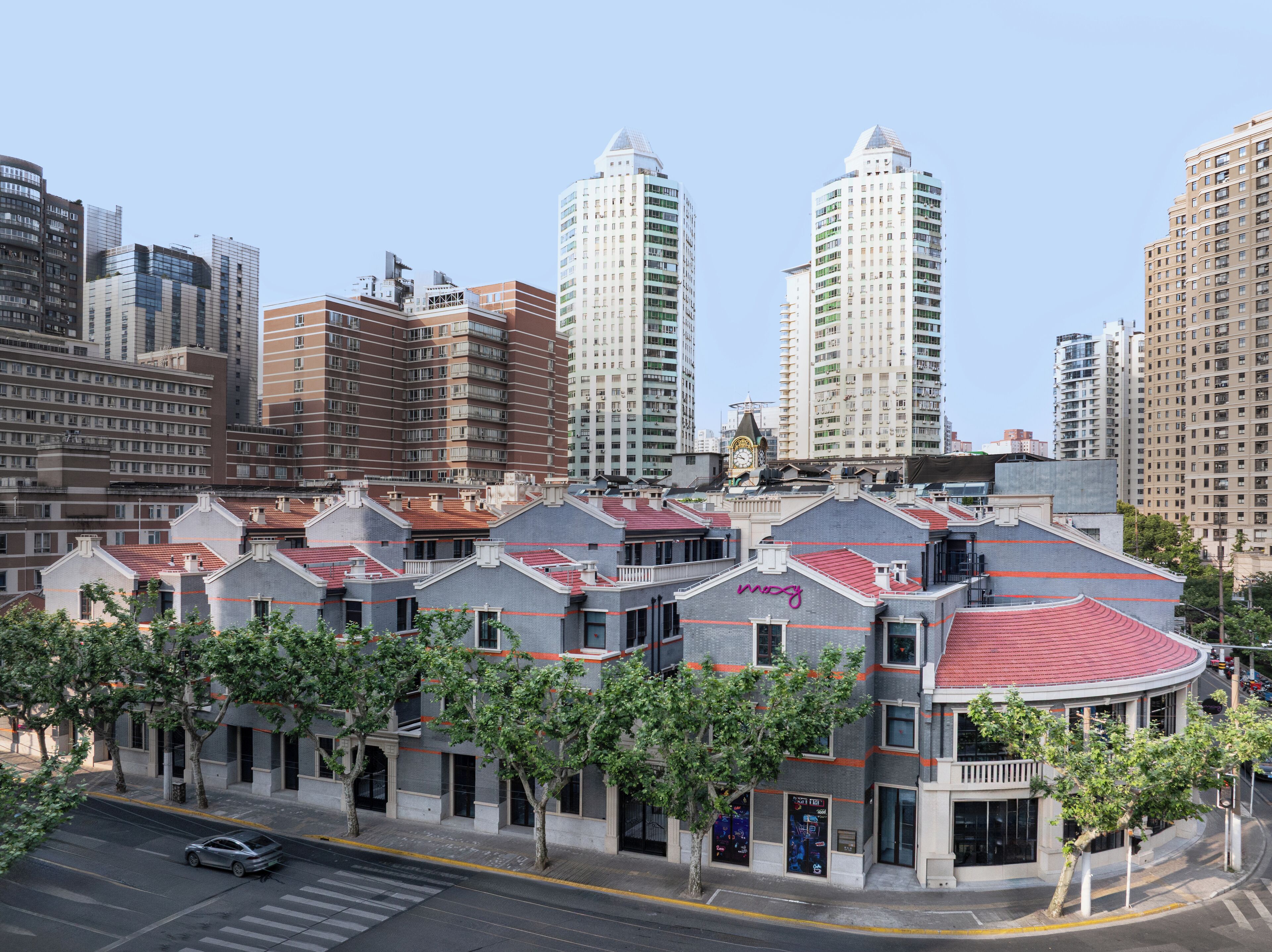 Un edificio moderno con techo rojo y una torre del reloj.