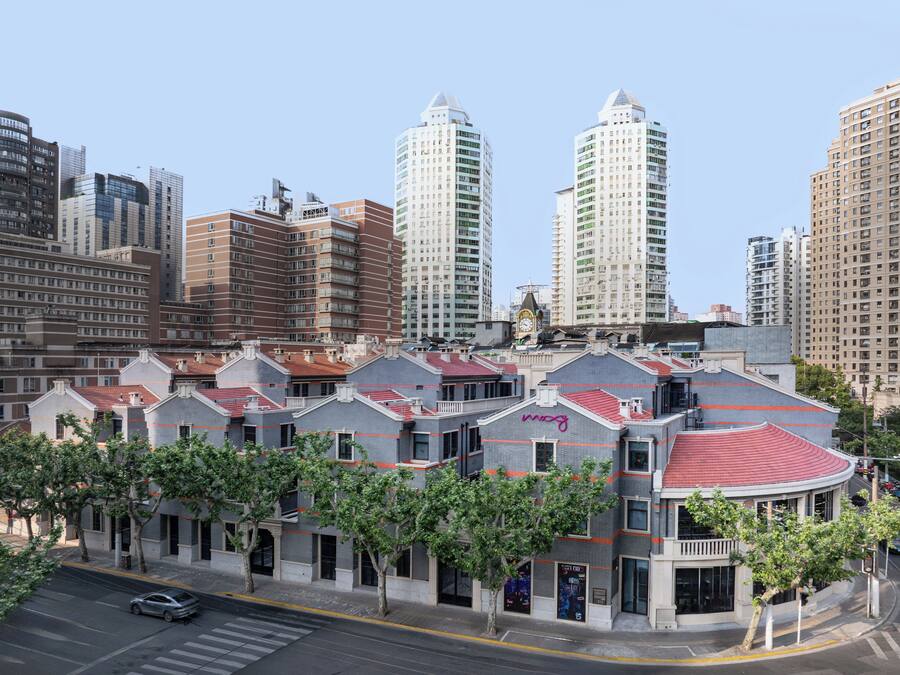 Un edificio moderno con techo rojo y una torre del reloj.