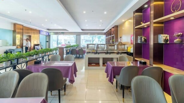 A modern restaurant with purple tablecloths, a central counter, and shelves with magazines. - Lavande Hotels (Guangzhou Fangcun Huadiwan) (Guangzhou)