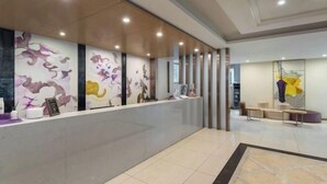 A modern reception area with a marble floor, a reception desk, and a seating area with sofas and a coffee table. - Lavande Hotels (Guangzhou Fangcun Huadiwan) (Guangzhou)