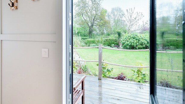 A view from a room with a wooden deck and a glass door leading to a garden. - Willow Lodge 1 - UK48642 (Taunton)