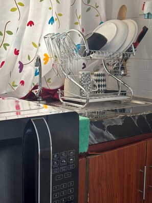 Enjoy cooking in this well-equipped kitchen with a dishwasher, drying rack, and ample utensils.