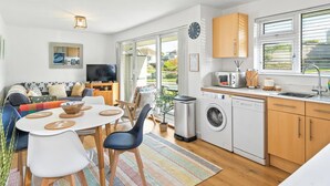 A modern apartment with a dining area, kitchen, and living room. - 2 bedroom accommodation in Newquay (Newquay)