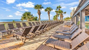Une terrasse ensoleillée avec des chaises longues et vue sur la piscine.