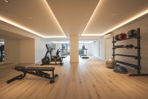 Et moderne fitnesscenter med træningsudstyr, vægtstativ og stor træningsbold.