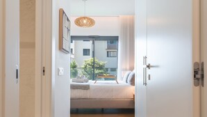 Una camera da letto con un letto, un comodino e vista del balcone esterno.