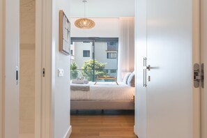 A bedroom with a bed, bedside table, and a view of the outside balcony. - Babi by the Sea by Atlantic Holiday (Funchal)