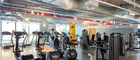 Ein Fitnessstudio mit Laufbändern, Crosstrainern und Krafttrainingsgeräten.