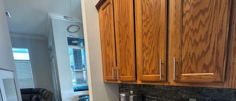 A kitchen with wooden cabinets, a microwave, and a granite countertop.