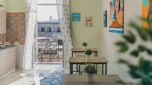 A cozy room with a balcony, a kitchen area, and a dining space. - DOMUS MARINA Rooms (Naples)