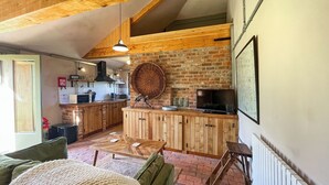 Ein gemütliches Wohnzimmer mit einem grünen Sofa, einem Holztisch und einer gestrickten Decke.