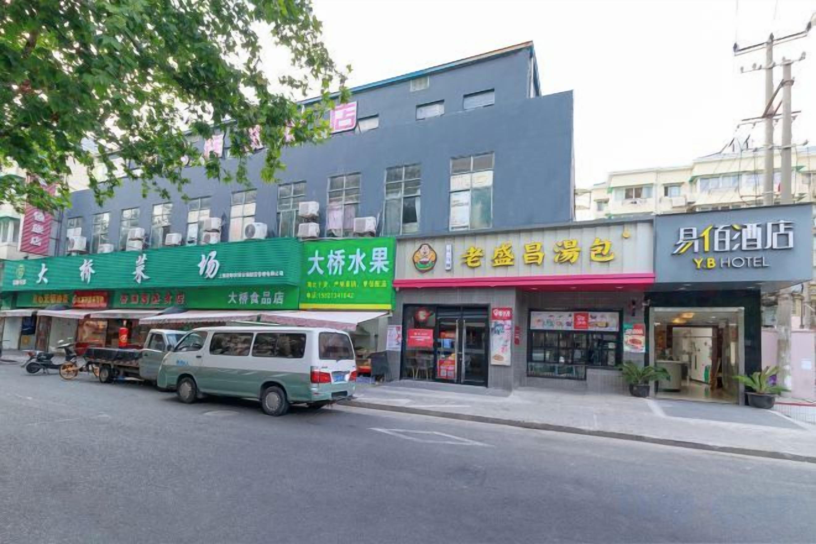 A street view with a hotel, a fruit market, and a restaurant.
