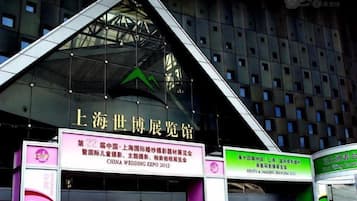 A building with a prominent sign indicating it is the 'Shanghai World Expo Center.'