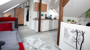 Een moderne loft slaapkamer met dakraam, een keuken met witte kasten en een eethoek.