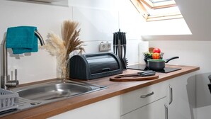 Een moderne keuken met dakraam, een roestvrijstalen spoelbak en een houten aanrecht.
