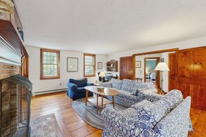 Télévision, cheminée, lecteur de DVD, livres