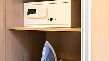 Un armario de madera con un microondas en la repisa superior y un planchador en la inferior.