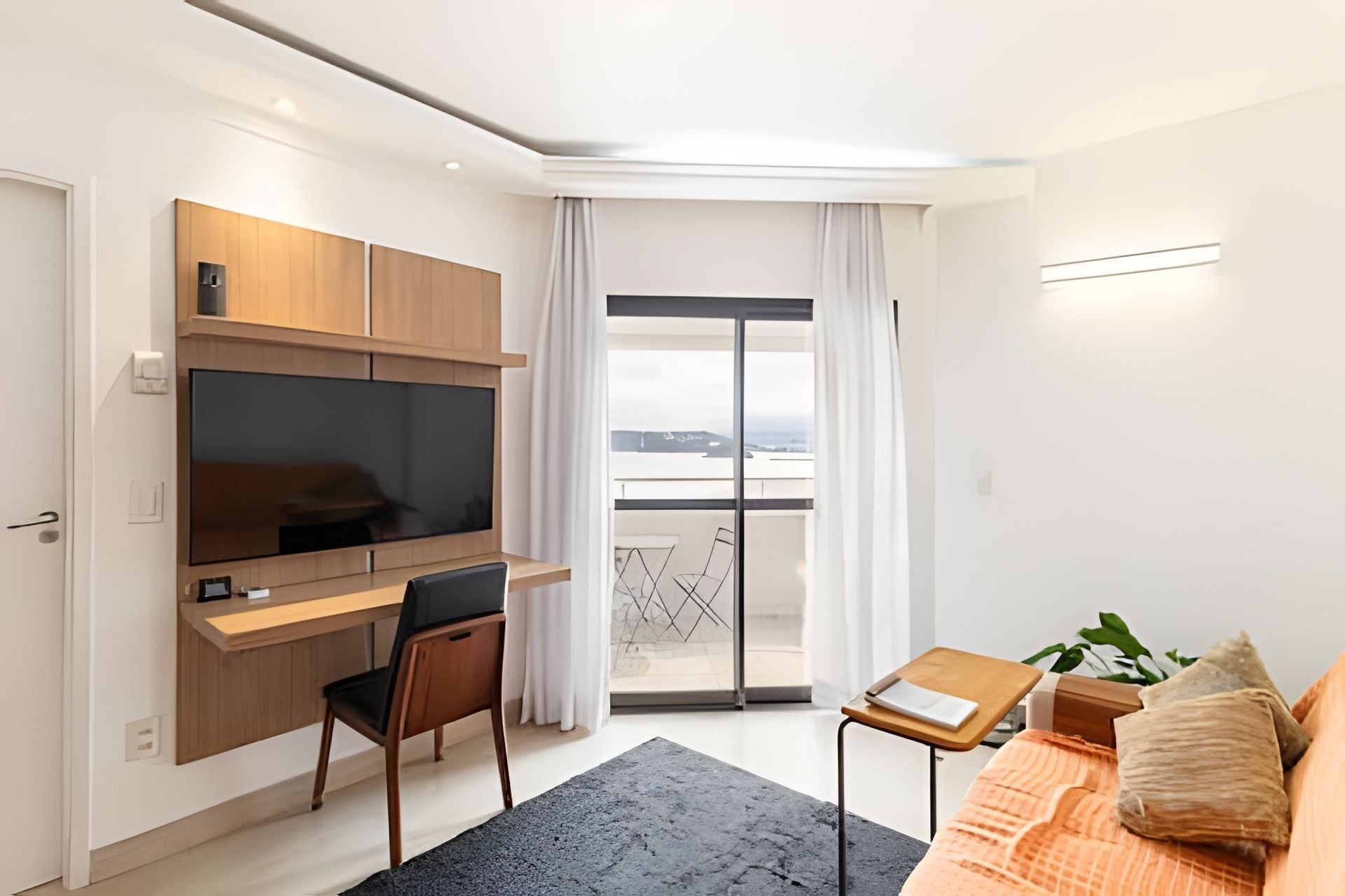 Una habitación moderna con escritorio, silla y sofá.