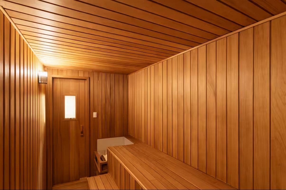 Et sauna-rum med trævægge og en bænk.