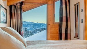 Un dormitorio con un ventanal que ofrece vistas a la montaña.
