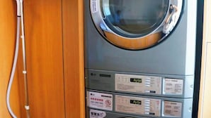 Een compacte, moderne wasmachine met meerdere bedieningspanelen en veiligheidsinstructies.