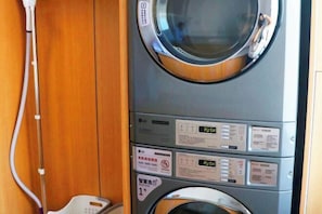 A compact, modern laundry machine with multiple control panels and safety instructions. - Ease Hotel (Yantai)
