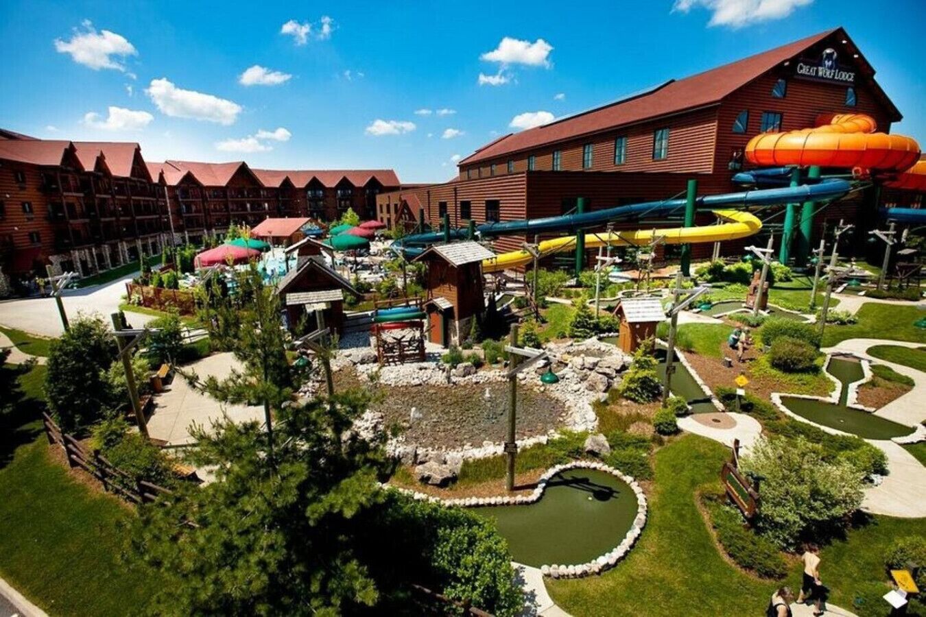 Un hotel con diversi edifici, un parco acquatico e uno stagno a forma di cuore.
