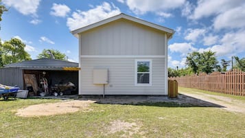 Stylish single-story home with a gabled roof and attached garage, featuring a front window and yard.