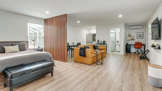 A modern, well-lit room with a bed, sofa, and a dining area. - WFH Friendly! Stylish Lakeland Studio (Lakeland)