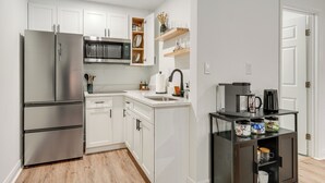 A modern kitchen with white cabinets, stainless steel appliances, and a coffee station. - WFH Friendly! Stylish Lakeland Studio (Lakeland)