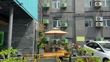 A courtyard with a pool, outdoor seating, and a car parked nearby.