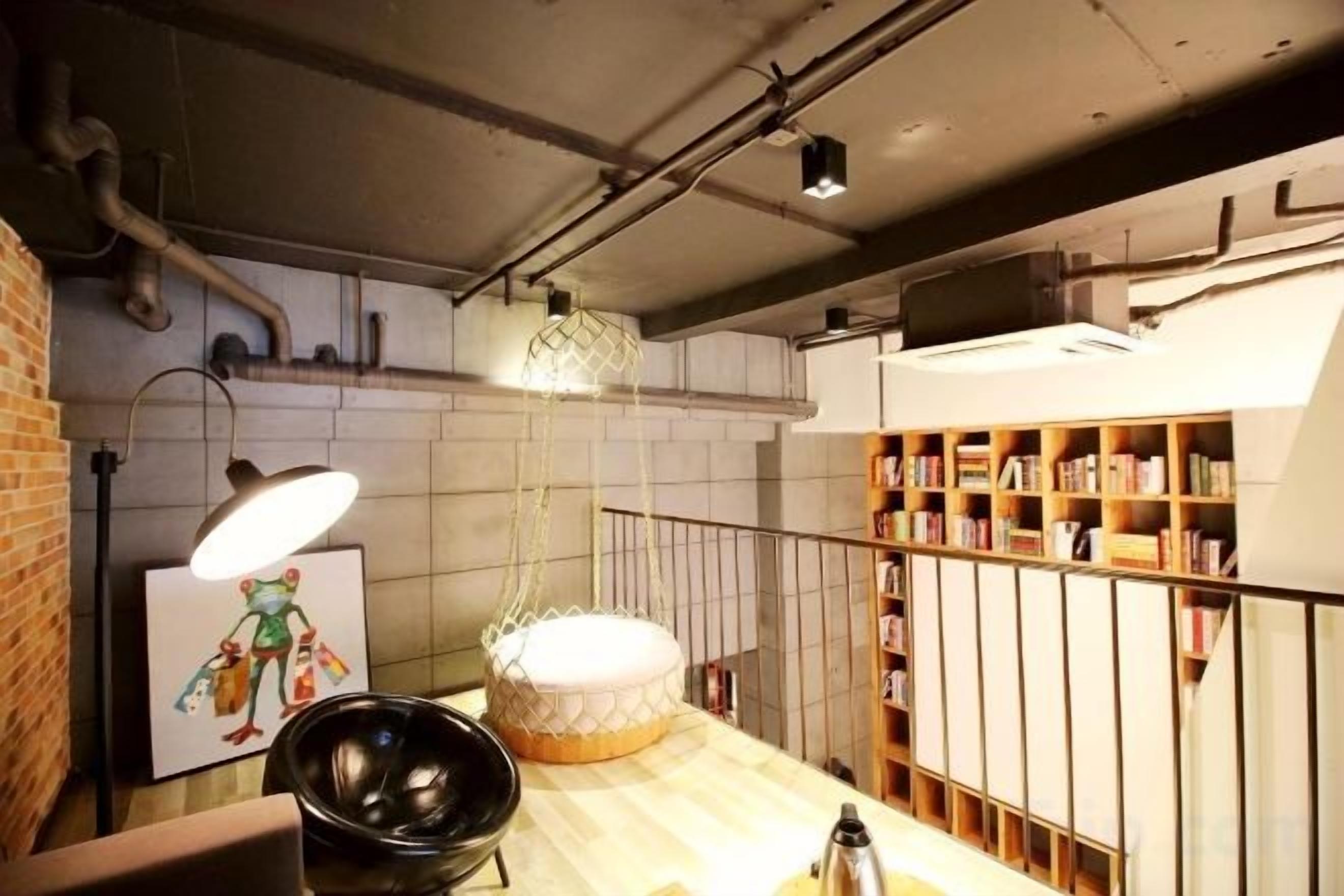 Una cocina con encimera de madera, una lámpara colgante y una estantería.