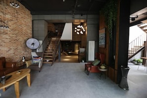 A modern interior with a staircase, a dining area, and a living space. - In Hotels (Qingdao)