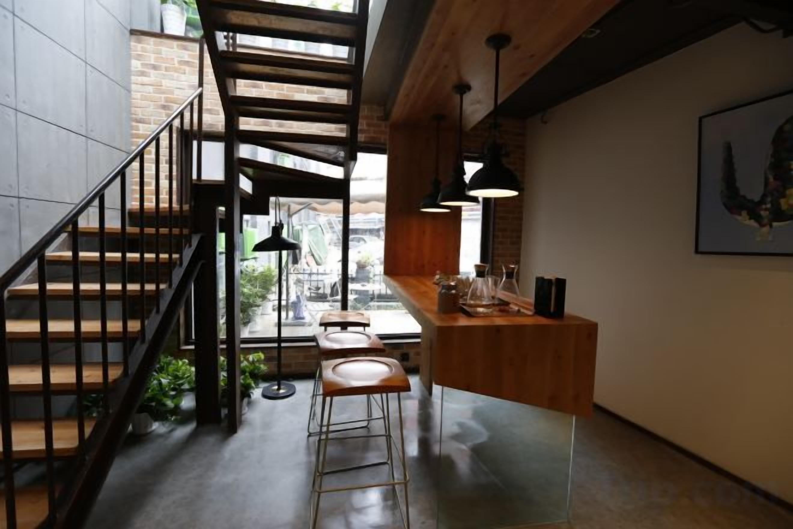 A modern interior with a staircase, bar area, and seating.