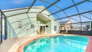 Ein Innenpool mit Glasdach, umgeben von einem hellen Gebäude mit einer Terrasse.